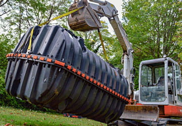 Septic tank being lowered into the ground